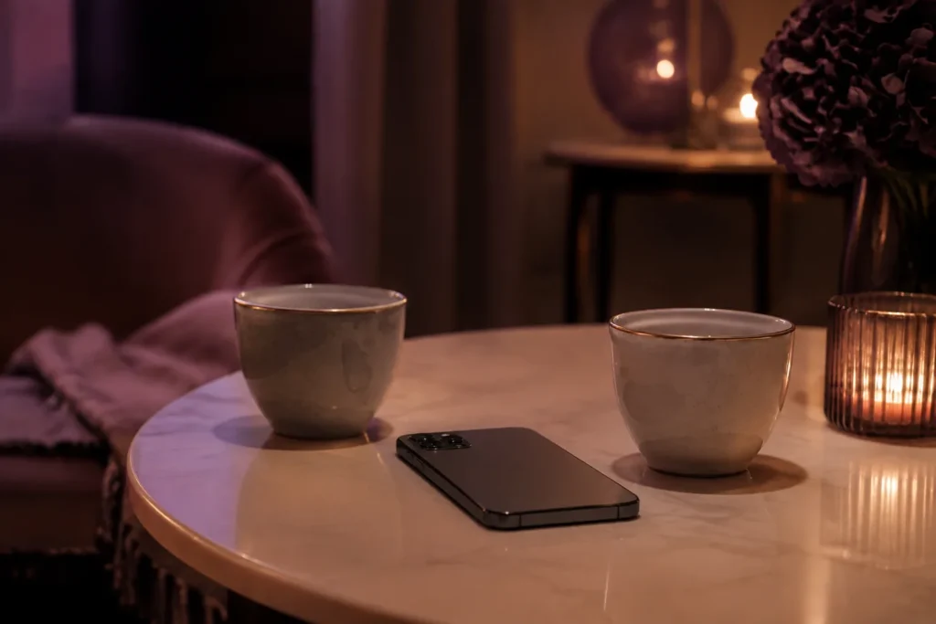 Telefon obok dwóch filiżanek symbolizujący niejednoznaczny kontakt z byłym partnerem