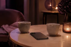 Telefon obok dwóch filiżanek symbolizujący niejednoznaczny kontakt z byłym partnerem